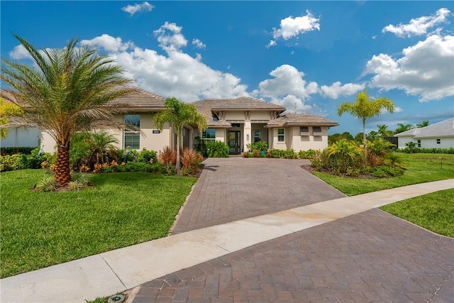 mediterranean / spanish house featuring a front lawn and stucco siding