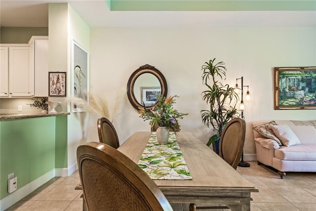 dining space with light tile patterned floors and baseboards