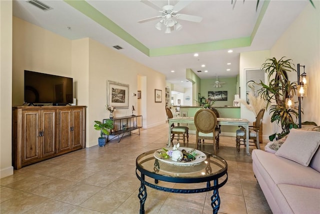 living room with visible vents, a ceiling fan, recessed lighting, baseboards, and a raised ceiling