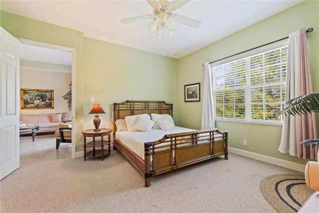 bedroom featuring a ceiling fan, baseboards, and light carpet