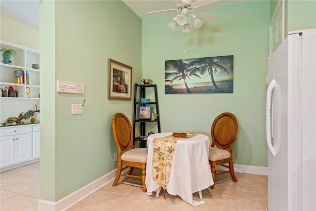 dining room with light tile patterned flooring, baseboards, and ceiling fan