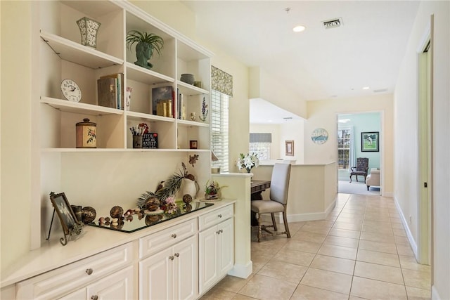 hallway featuring recessed lighting, visible vents, baseboards, and light tile patterned flooring