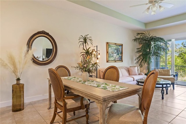 dining space with light tile patterned floors, baseboards, and ceiling fan