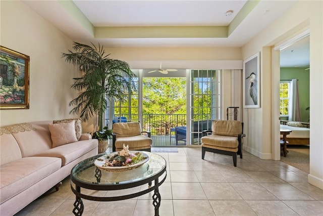 tiled living room featuring baseboards and ceiling fan