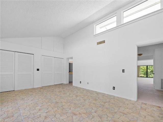 interior space featuring high vaulted ceiling and a textured ceiling