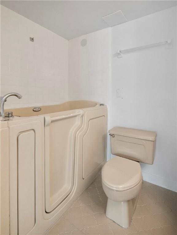 bathroom featuring a tub to relax in and toilet