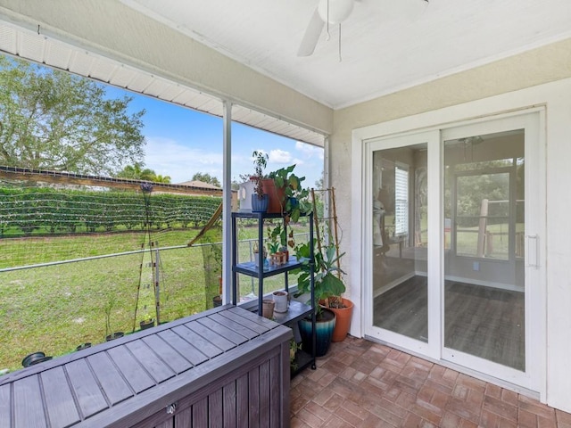 unfurnished sunroom with ceiling fan