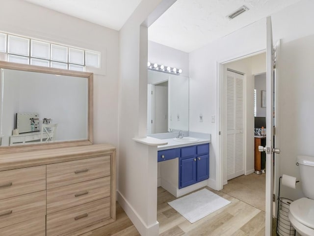 bathroom with vanity, wood-type flooring, and toilet