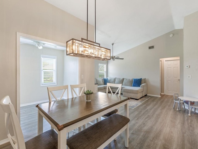 dining area featuring hardwood / wood-style flooring, high vaulted ceiling, and ceiling fan