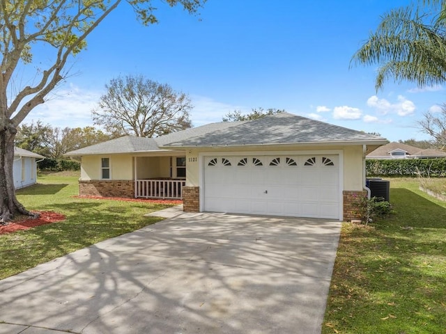 ranch-style house with cooling unit, a garage, a front yard, and covered porch