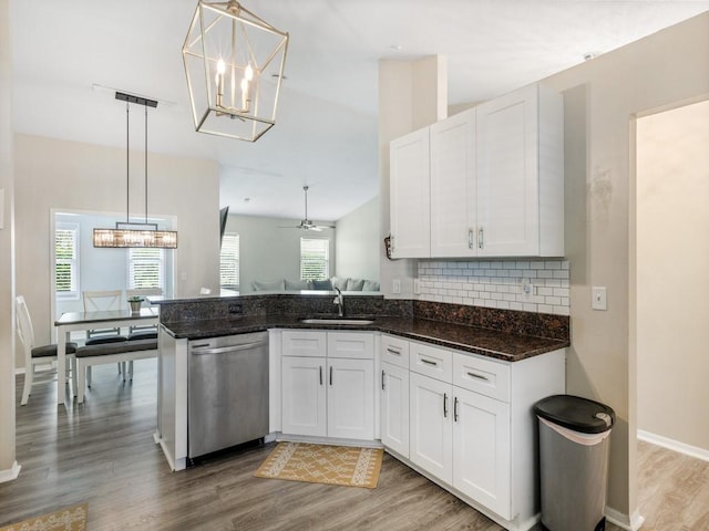 kitchen with dishwasher, dark stone countertops, white cabinets, and decorative light fixtures