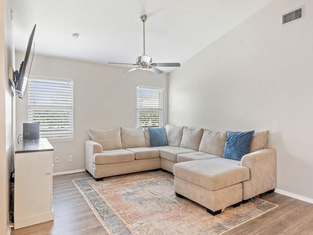 living room with lofted ceiling, hardwood / wood-style flooring, and ceiling fan