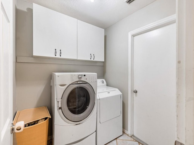 laundry room with cabinets, independent washer and dryer, and light tile patterned floors