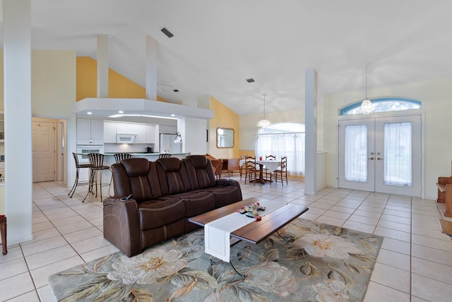 living room featuring high vaulted ceiling, french doors, and light tile patterned floors