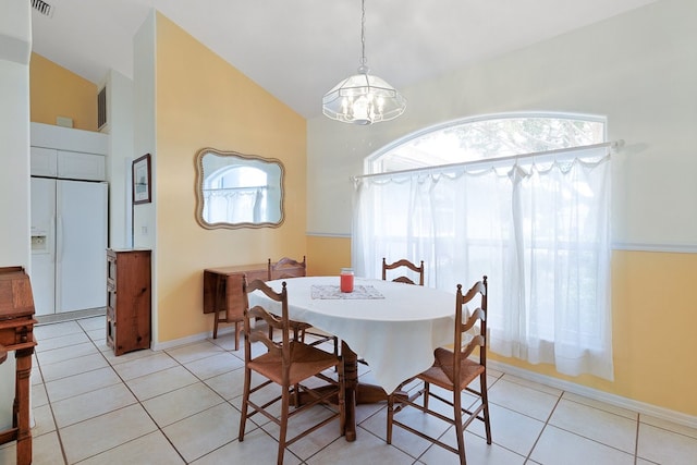 dining area with a wealth of natural light, lofted ceiling, light tile patterned floors, and a notable chandelier