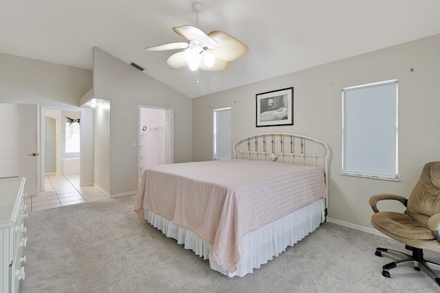 carpeted bedroom featuring ensuite bath, ceiling fan, a walk in closet, a closet, and vaulted ceiling