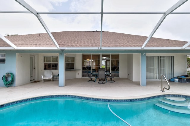 view of swimming pool with glass enclosure and a patio