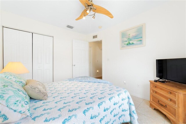 bedroom with a closet, ceiling fan, visible vents, and light tile patterned flooring