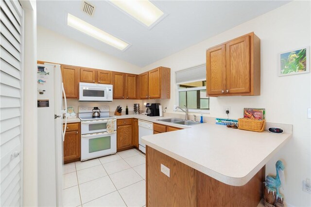 kitchen featuring light countertops, a peninsula, white appliances, a sink, and light tile patterned floors