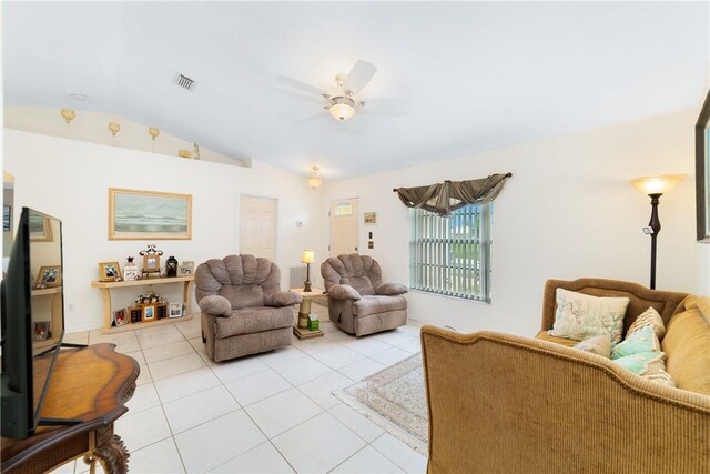 living area with light tile patterned flooring, visible vents, lofted ceiling, and a ceiling fan