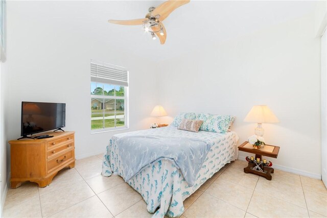 bedroom featuring baseboards, ceiling fan, and light tile patterned floors