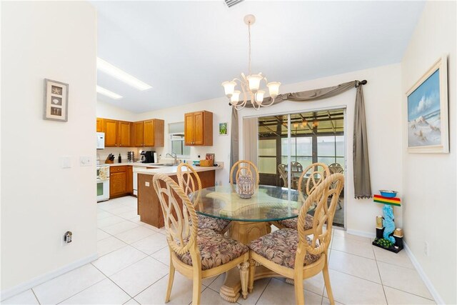 dining area featuring baseboards, vaulted ceiling, light tile patterned floors, and a chandelier