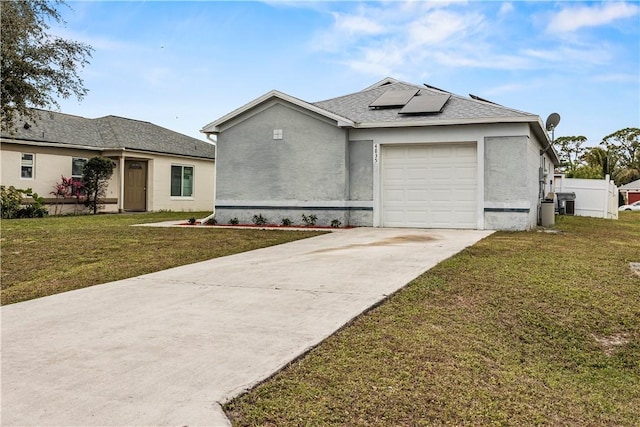 ranch-style home with a garage, a front yard, and solar panels