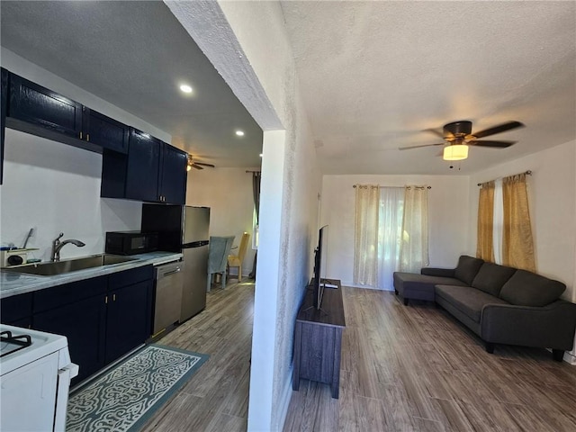 kitchen featuring dishwasher, white range with gas cooktop, ceiling fan, dark cabinetry, and a textured ceiling