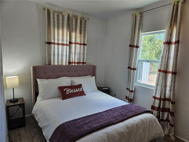 bedroom with multiple windows and wood finished floors