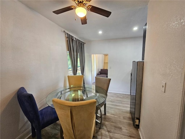 dining area featuring a textured wall, wood finished floors, ceiling fan, and recessed lighting
