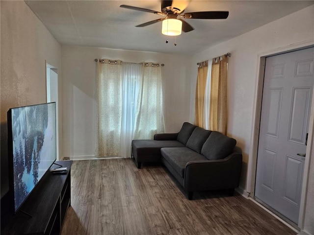 living area with wood finished floors and ceiling fan