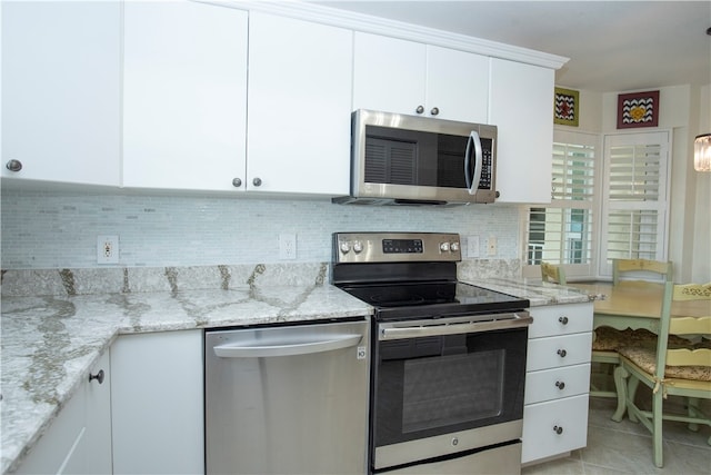 kitchen with light stone counters, white cabinetry, and appliances with stainless steel finishes