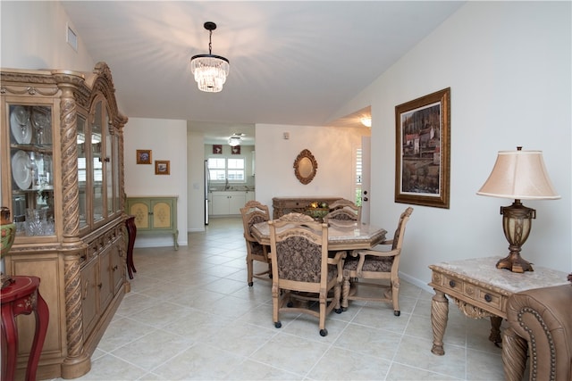 tiled dining area with a chandelier and vaulted ceiling