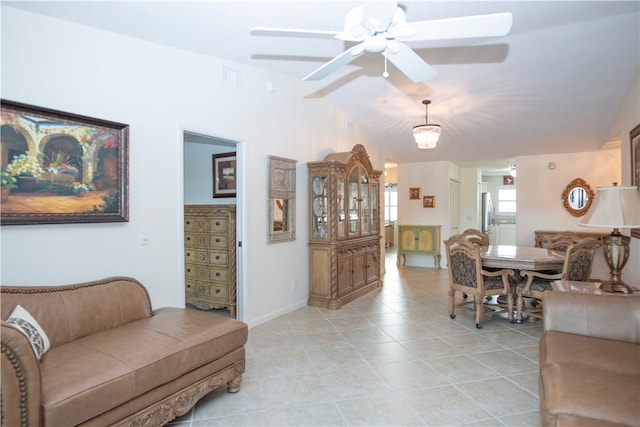 tiled living room featuring ceiling fan and lofted ceiling