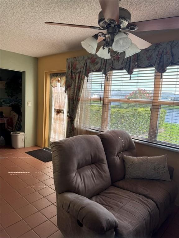 tiled living room with ceiling fan and a textured ceiling