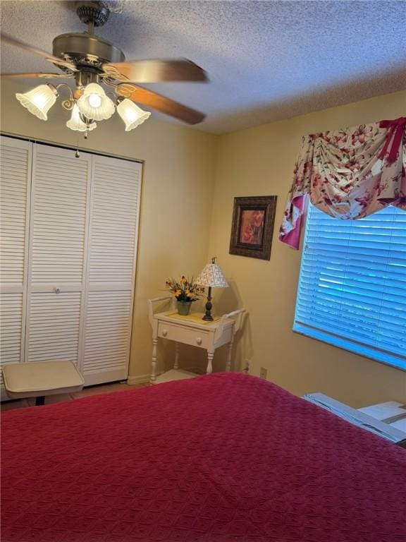 bedroom with ceiling fan, a closet, and a textured ceiling