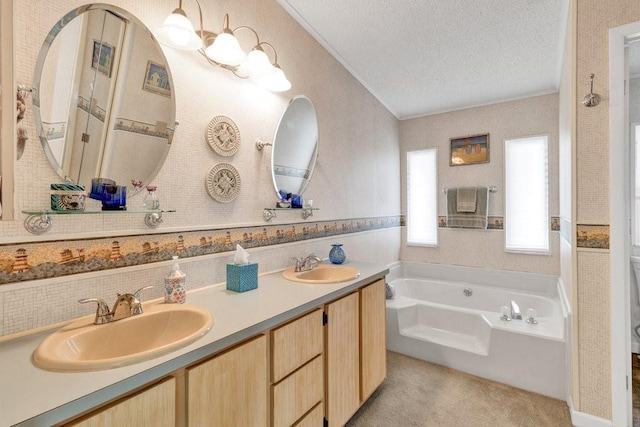 bathroom featuring a bathing tub, vanity, and a textured ceiling