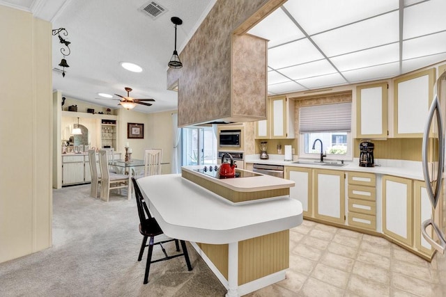 kitchen featuring pendant lighting, sink, ceiling fan, a kitchen bar, and stainless steel appliances