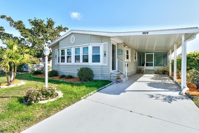 manufactured / mobile home with a front lawn and a carport