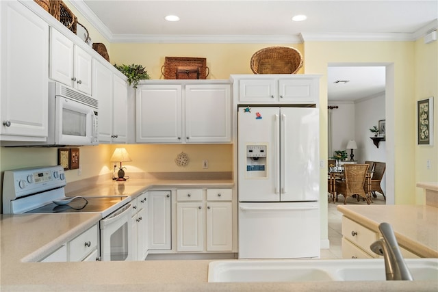 kitchen with white appliances, sink, ornamental molding, and white cabinets