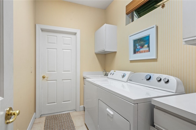 laundry room with cabinets, sink, washer and dryer, and light tile patterned floors