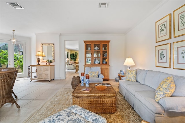 tiled living room featuring ornamental molding and french doors