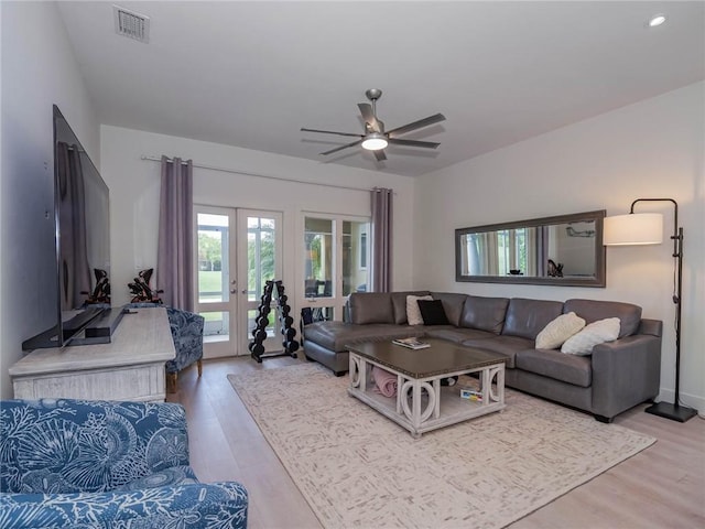 living room with hardwood / wood-style floors, ceiling fan, and french doors