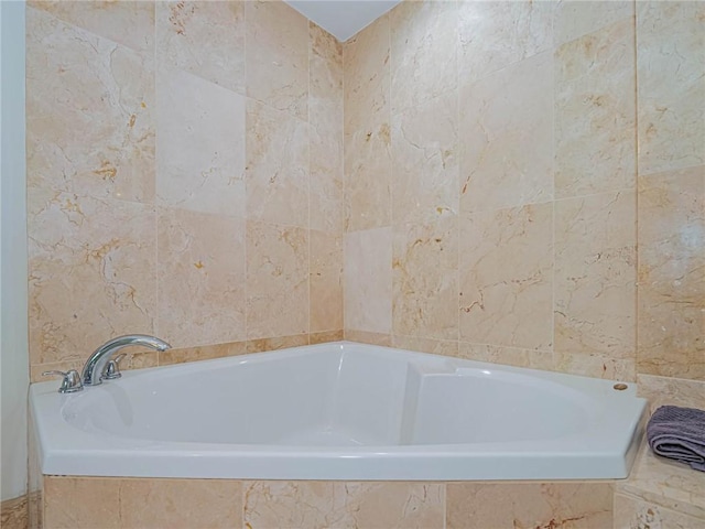 bathroom featuring a relaxing tiled tub and tile walls