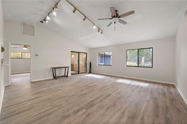 2821 21st Pl, Vero Beach, FL 32960 - empty room with ceiling fan, lofted ceiling, rail lighting, plenty of natural light, and a textured ceiling