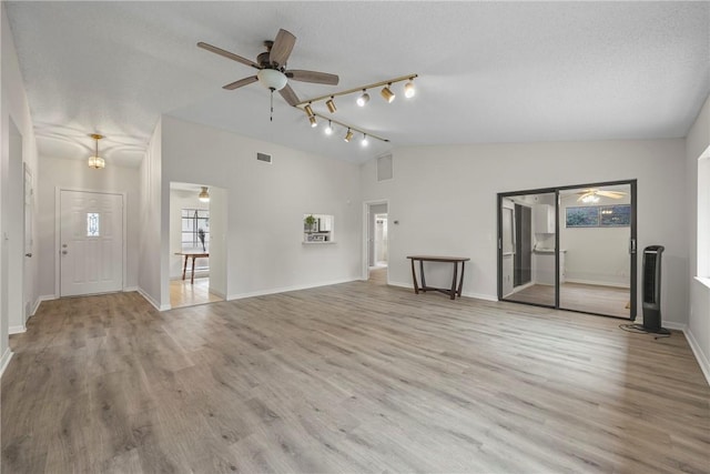 2821 21st Pl, Vero Beach, FL 32960 - unfurnished living room featuring ceiling fan, vaulted ceiling, track lighting, wood finished floors, and baseboards