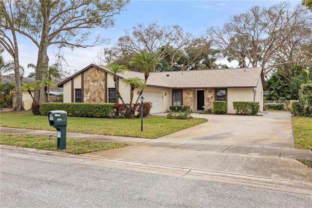 2821 21st Pl, Vero Beach, FL 32960 - view of front of house featuring concrete driveway, a front lawn, a garage, stucco siding, and stone siding