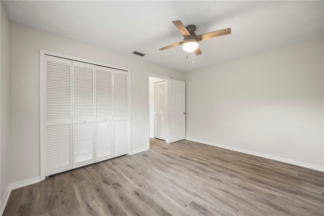 2821 21st Pl, Vero Beach, FL 32960 - unfurnished bedroom with wood finished floors, baseboards, a closet, and ceiling fan