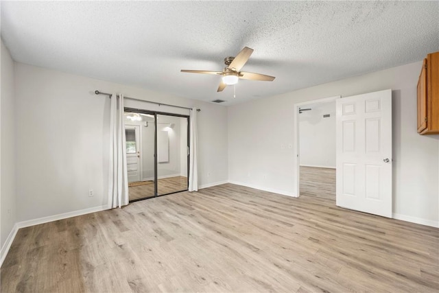 2821 21st Pl, Vero Beach, FL 32960 - unfurnished bedroom featuring light wood-style floors, baseboards, a textured ceiling, and a ceiling fan