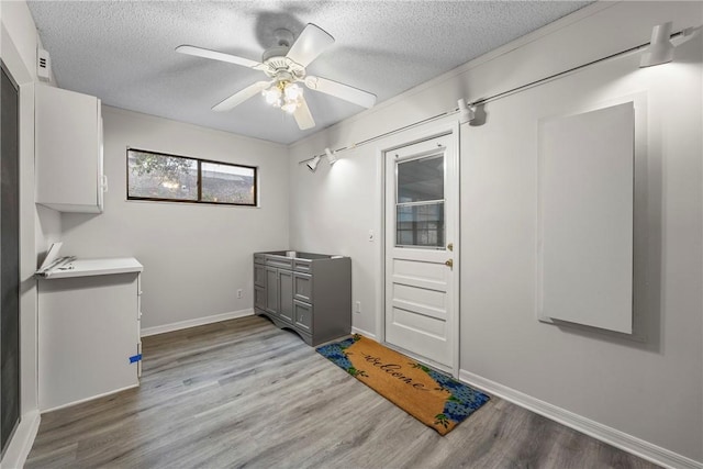 2821 21st Pl, Vero Beach, FL 32960 - laundry area featuring a textured ceiling, light wood-style floors, ceiling fan, and baseboards
